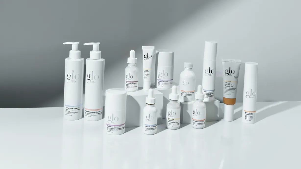 Fifteen Glo Skin Beauty cleansers, serums and moisturisers arranged on a pale grey surface